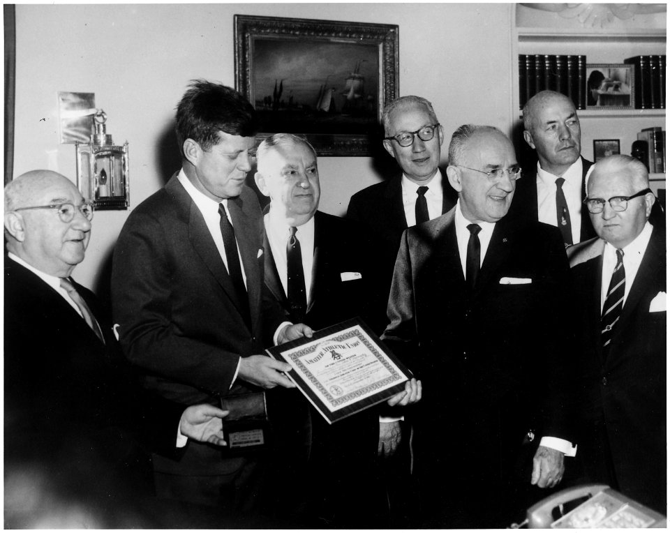 President Kennedy is presented AAU Life Membership Plaque. (L-R) Ed Rosenblum, Chairman AAU Life Membership... - NARA - 194175