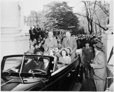 President Harry S. Truman and Vice President-elect sitting on the back of an open car in front of the White House.... - NARA - 199945