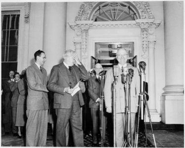President Harry S. Truman, Vice President-elect Alben W. Barkley, and others standing on the front porch of the White... - NARA - 199948