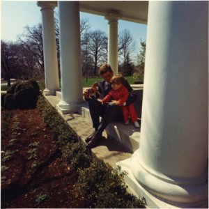 President Kennedy plays with son John F. Kennedy, Jr. White House, West Wing Collonade - NARA - 194251