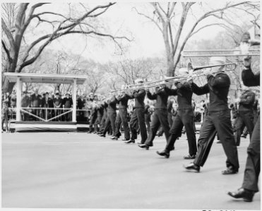 President Truman at the reviewing stand (in the distance) as the Navy Band marches by in the Army Day parade in... - NARA - 199768