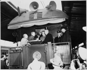 President Harry S. Truman and Vice President-elect Alben W. Barkley greet two unidentified men on the rear platform... - NARA - 199943 photo