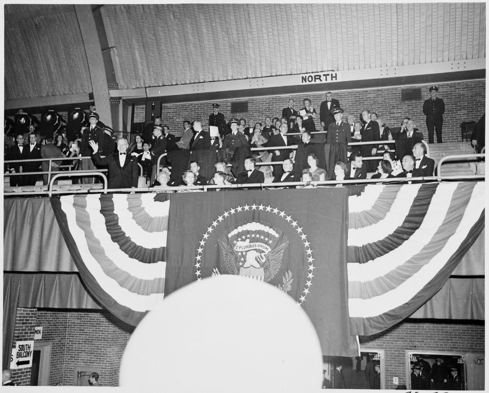 President Truman waves to the crowd from the bleachers at the inaugural gala at the National Guard Armory in... - NARA - 199988