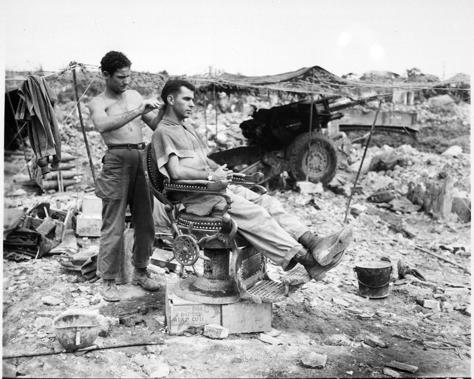 Private First Class Troy Dixon, Leadhill, Arkansas, uses a Japanese barber chair to cut the hair of Sergeant John... - NARA - 531303