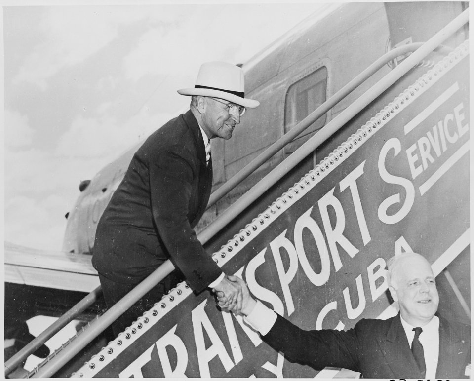 President Truman shakes hands with White House doorkeeper William Simmons as he descends the airplane stairs upon his... - NARA - 199781