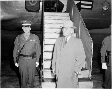 President Truman at the bottom of the stairs leading to the presidential airplane. He is leaving for a vacation at... - NARA - 199672 photo