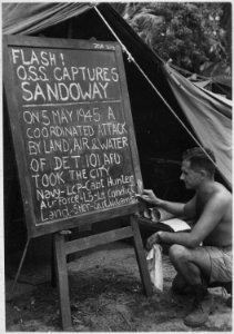 Private First Class Edeleanu prints news bulletin on bulletin board outside Intelligence tent of Kyaukpyu Camp the... - NARA - 540055