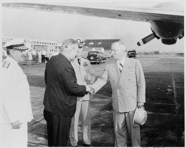 President Truman shakes hands with Brazilian Ambassador Carlos Martins as they prepare to board the presidential... - NARA - 199691 photo