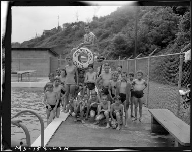 Rear Admiral Joel T. Boone with group of miner's children at swimming pool which was constructed by popular... - NARA - 540301