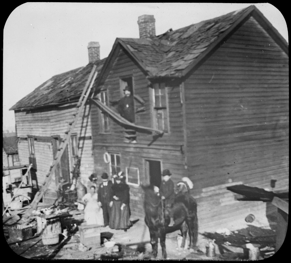 Residents in front of a dilapidated frame house in Kansas City, ca. 1900 - NARA - 535470