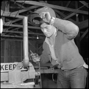 Rohwer Relocation Center, McGehee, Arkansas. In repairing a piece of farm machinery, Chester Ishii . . . - NARA - 539384