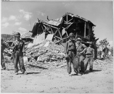 Republic of Korea military police pose before the ruins of a devastated building in Pohang. Most buildings that... - NARA - 520773