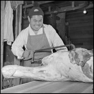 Rohwer Relocation Center, McGehee, Arkansas. Sam Takeda, a former west coast butcher, cutting a be . . . - NARA - 539370 photo