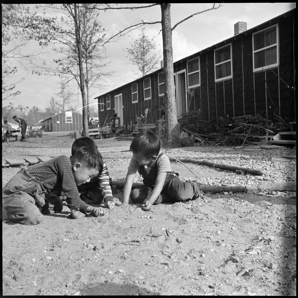 Rohwer Relocation Center, McGehee, Arkansas. Three small boys compete in a staff marble game on a S . . . - NARA - 538905