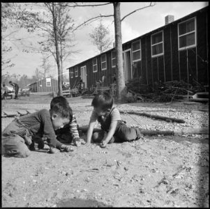 Rohwer Relocation Center, McGehee, Arkansas. Three small boys compete in a staff marble game on a S . . . - NARA - 538905