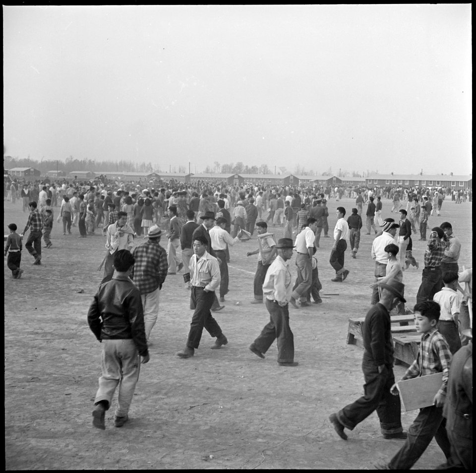 Rohwer Relocation Center, McGehee, Arkansas. The crowd floods the football field as the game ends. . . . - NARA - 538890
