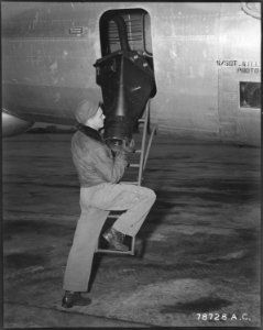 S-Sgt. Arthur L. Goins, combat crew photographer on the RB-29 of the 31st Strategical Reconnaissance Squadron, loads... - NARA - 542215
