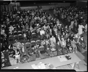 Salinas, California. Seated in family groups, evacuees of Japanese ancestry check in at Armory befo . . . - NARA - 536192