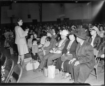 Salinas, California. Seated in family groups, evacuees of Japanese ancestry check in at Armory befo . . . - NARA - 536190