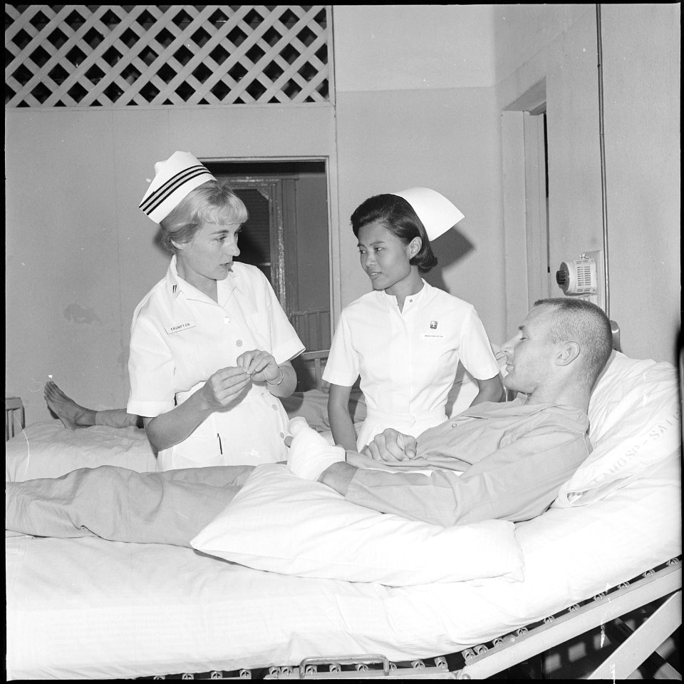 Saigon, South Vietnam....Lieutenant Frances Crumpton and Miss Nangnoi Tongkim, a Thai nurse, talk with an American... - NARA - 558528