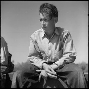 San Joaquin Valley, California. Contract Labor. From Oklahoma, 22 years old. With idle hands, he sits in the sun of... - NARA - 532162 photo