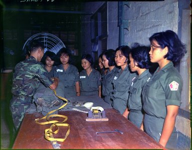 Sergeant Sans instructs WAC class on pack closing the T-10 Parachute at the 90th Aerial Equipment Depot, Saigon. - NARA - 530629