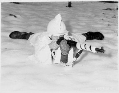 Sergeant. (or Tec 4) Marvin E. Eans, Jr., demonstrates the new snow cape being used by First U.S. Army Infantrymen in... - NARA - 531227