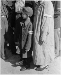Six-year-old war orphan with Buchenwald badge on his sleeve waits for his name to be called at roll call at... - NARA - 531302