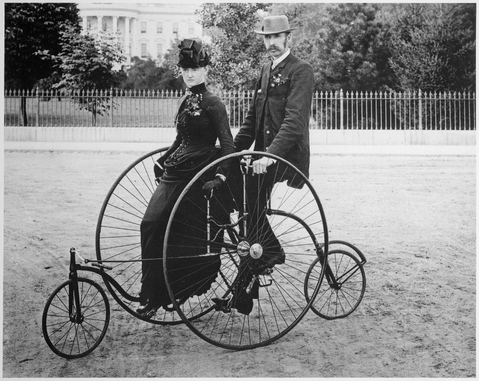 Smartly dressed couple seated on an 1886-model bicycle for two - NARA - 519711 photo