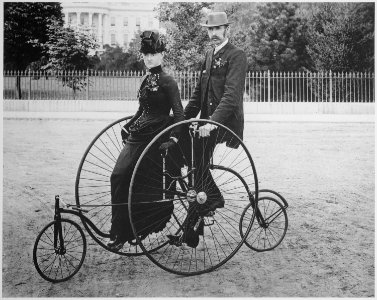 Smartly dressed couple seated on an 1886-model bicycle for two - NARA - 519711 photo
