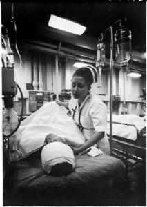 South China Sea....A nurse tends a patient just out of surgery in the intensive care ward of the hospital ship USS... - NARA - 558532 photo