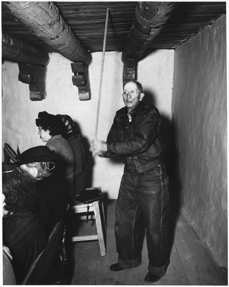 Taos County, New Mexico. Church bell is rung to call villagers to Mass at Arroyo Hondo. - NARA - 521916