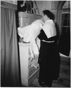 Taos County, New Mexico. Father Morgan puts on vestments for Mass in vestry of church at Arroyo Hon . . . - NARA - 521914