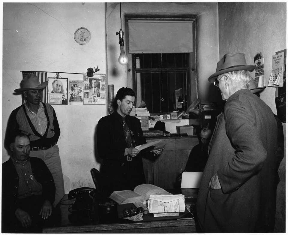 Taos County, New Mexico. Sheriff Montoya discusses business with a process server. - NARA - 521883