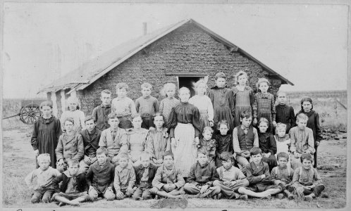 Teacher and children in front of sod schoolhouse. Woods Co., Okla. Terr., ca. 1895 - NARA - 516448 photo