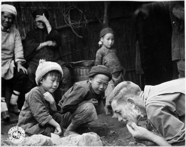 These two Chinese youngsters are fascinated by the sight of an American soldier shaving in the open. Yunnan, China. - NARA - 531203