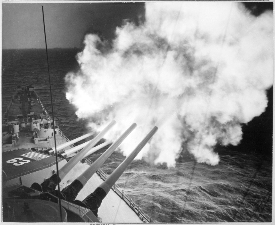 The USS Missouri fires 16-inch shell into enemy lines at Hungnam. A 16-inch 3-gun salvo is on its way to commies. - NARA - 520788
