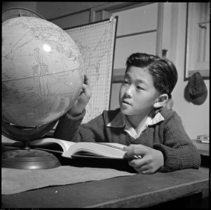 Topaz, Utah. A globe is used by this pupil in the high first grade, to assist in his geography lesson. - NARA - 536993