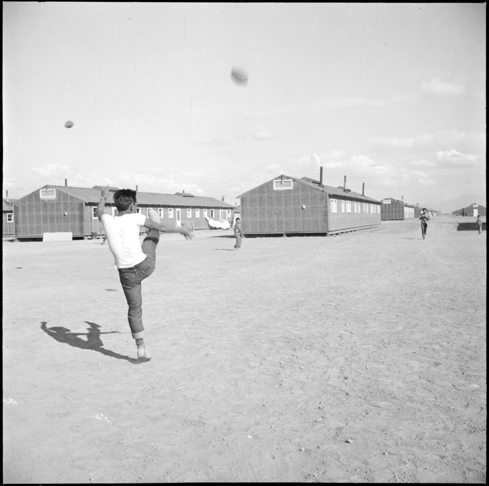 Topaz, Utah. A warm sunny afternoon at the Topaz Relocation Center finds footballs in the air every . . . - NARA - 538688