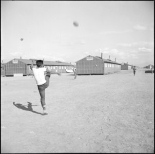 Topaz, Utah. A warm sunny afternoon at the Topaz Relocation Center finds footballs in the air every . . . - NARA - 538688