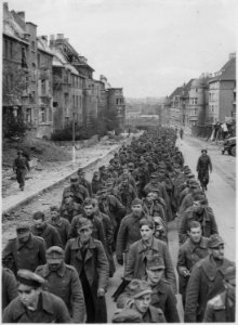 The endless procession of German prisoners captured with the fall of Aachen marching through the ruined city streets... - NARA - 541598