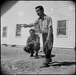 Topaz, Utah. Henry Yamashiro watches Tad Horita pitch a game of horseshoes. Members of this fire d . . . - NARA - 537011