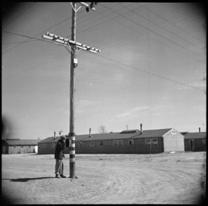 Topaz, Utah. An evacuee fireman checks with his chief from a fire alarm box, which is located on a . . . - NARA - 536995 photo