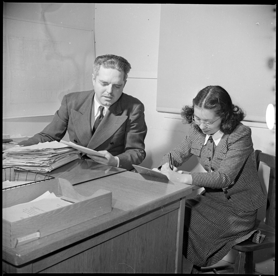 Topaz, Utah. Gilbert L. Niesse, Administrative Officer, is shown dictating to his evacuee secretary . . . - NARA - 537007