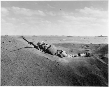 This Marine, member of the Fighting Fourth Marine Division, threatens the enemy even in death. His bayonet fixed at... - NARA - 532541 photo