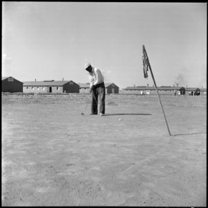 Topaz, Utah. This former California tournament runner-up keeps his golf form by first preparing a s . . . - NARA - 538705 photo