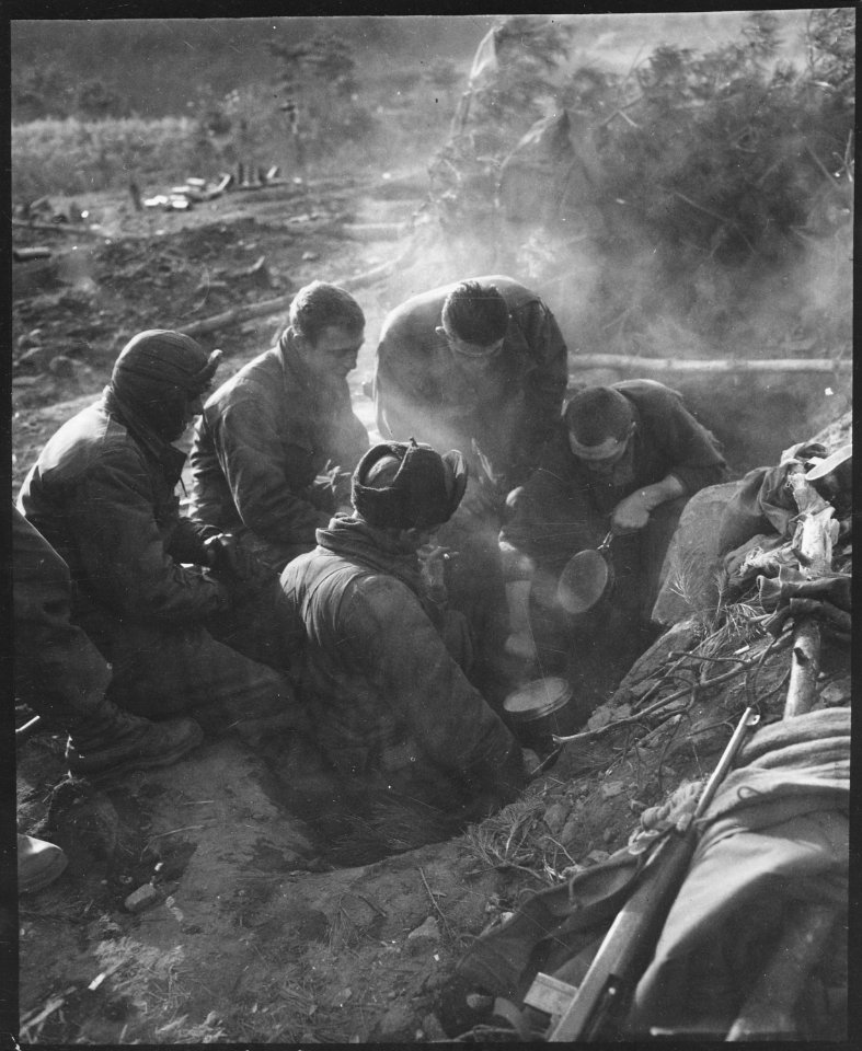 These men of the Heavy Mortar Company, 7th Infantry Regiment, go native, cooking rice in their foxhole in the... - NARA - 531391