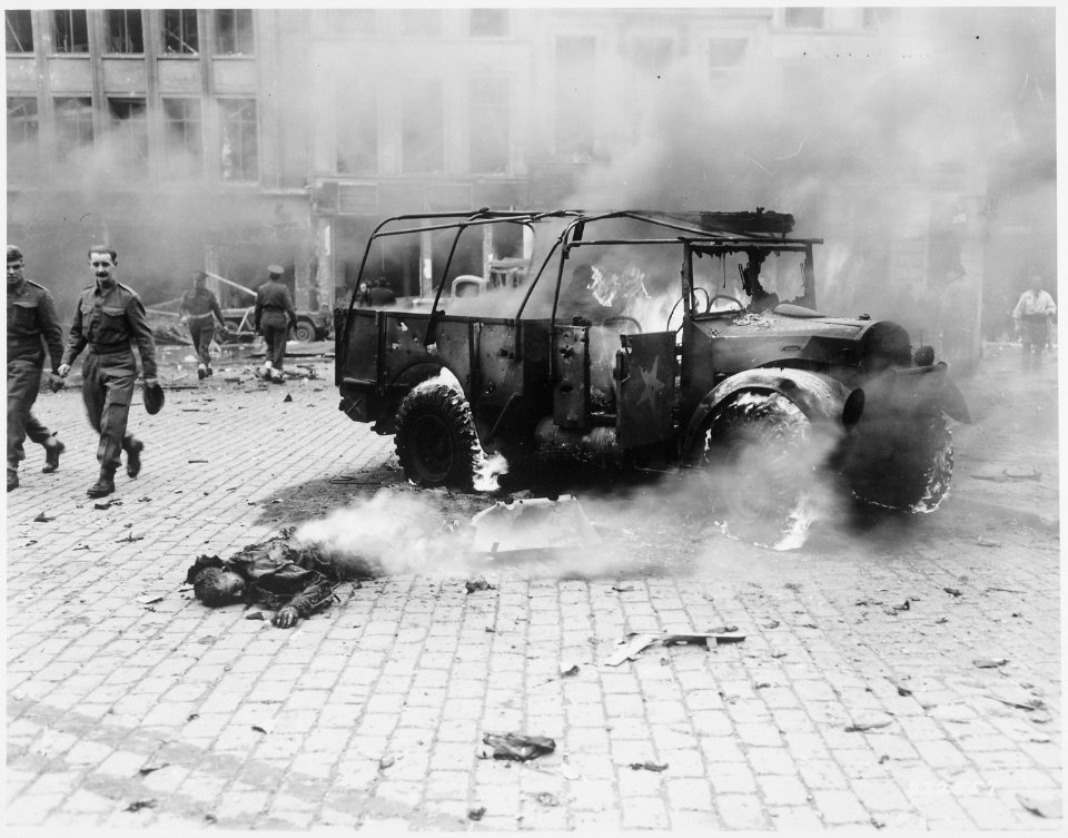 This boy's dead body, aflame, bears ghastly witness of the horror of the damage done by V-2 on main intersection in... - NARA - 531329