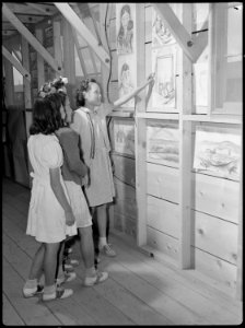 Tule Lake Relocation Center, Newell, California. An evacuee school girl proudly shows friends her a . . . - NARA - 538409