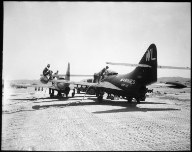 Two Pantherjets are refueling after rockets have been hung under the wings. - NARA - 532419